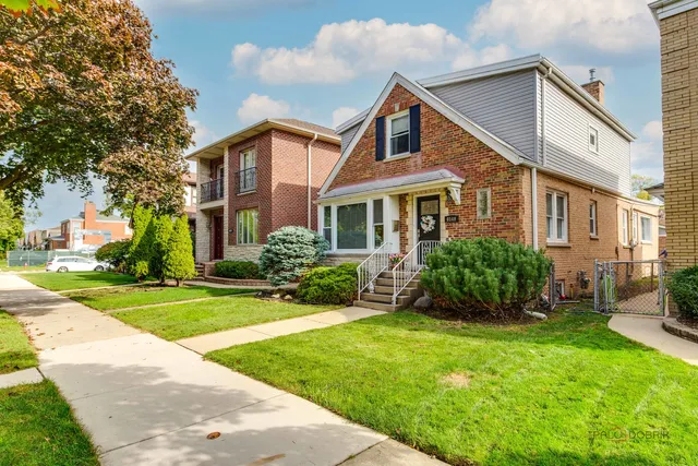 a front view of a house with a yard and potted plants
