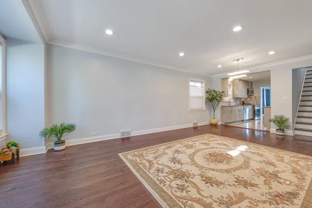 a view of a kitchen with kitchen island a stove a wooden floor and a dining table