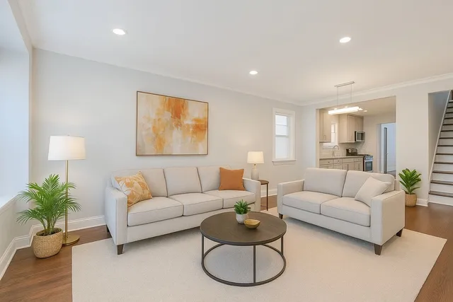 a living room with furniture potted plant and a wooden floor