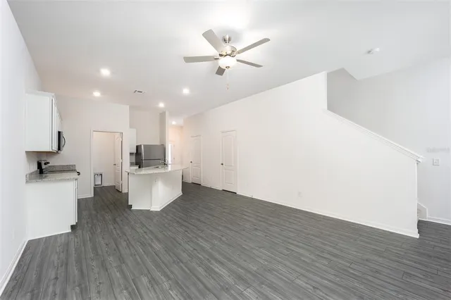 a view of kitchen with cabinets stainless steel appliances and wooden floor