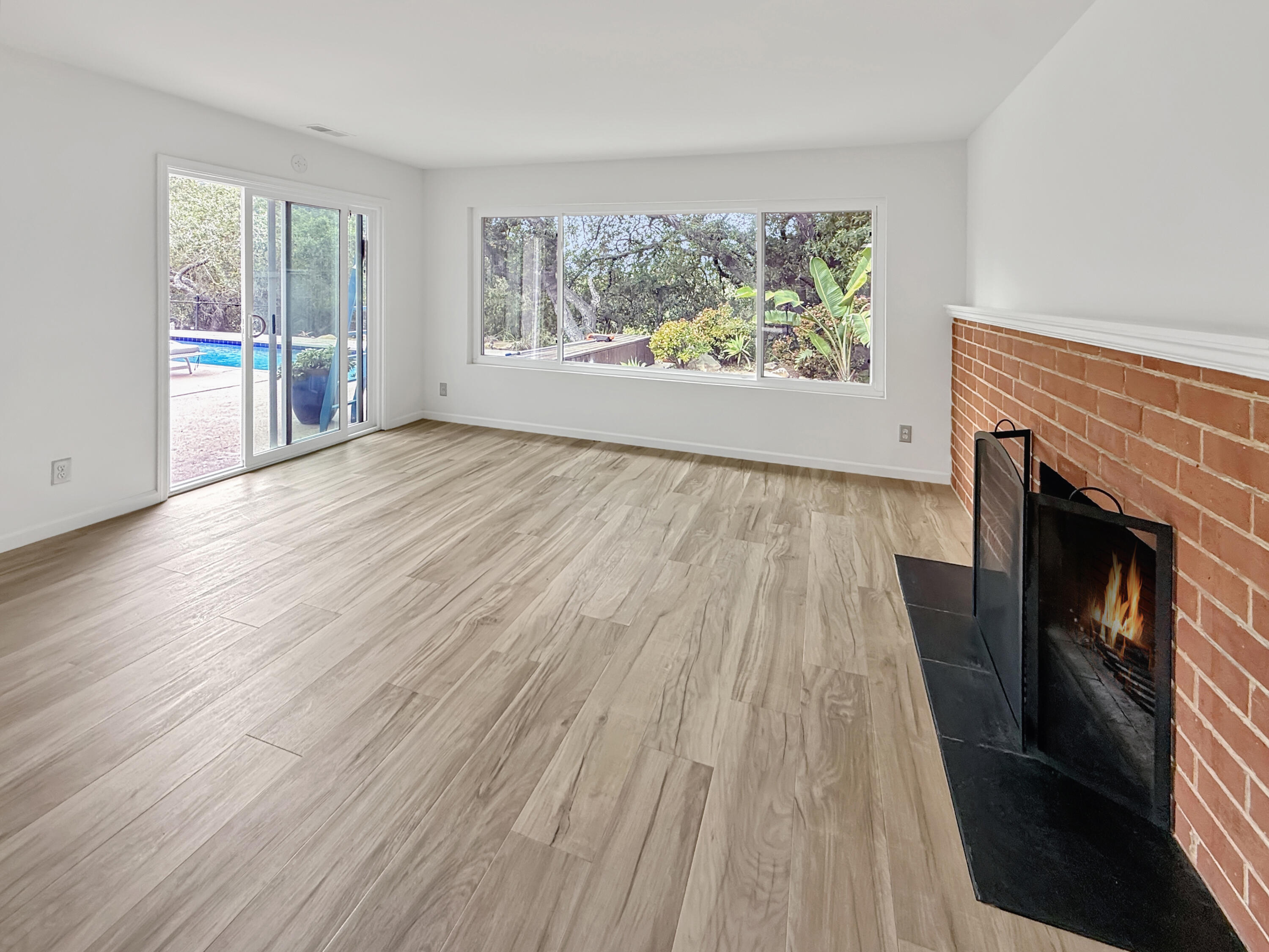 2020 Foothill Road Santa Barbara, CA 93105 - Photo 5 of 11 an empty room with wooden floor a fireplace and windows