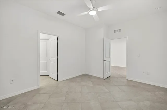 an empty room with a ceiling fan and a window