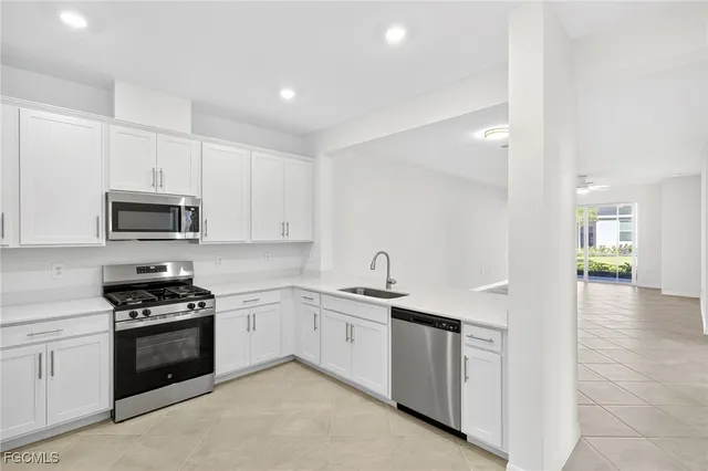 a kitchen with white cabinets stainless steel appliances and sink