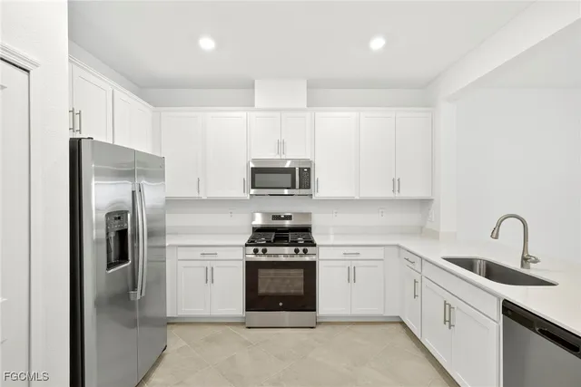 a kitchen with white cabinets and stainless steel appliances