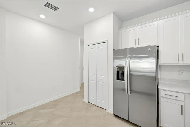 a metallic refrigerator freezer sitting in a kitchen