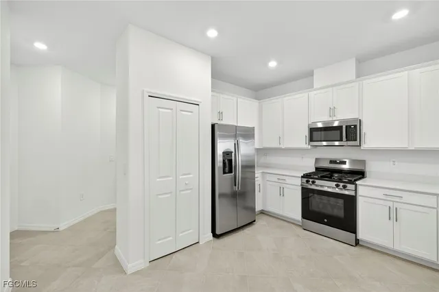 a kitchen with stainless steel appliances granite countertop a refrigerator a stove a sink and a microwave