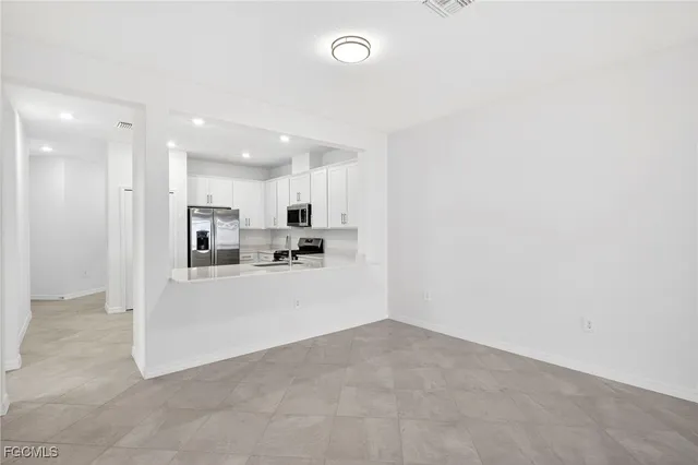 a view of a kitchen with refrigerator and windows