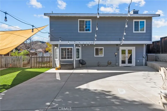 a view of a house with a yard and large tree