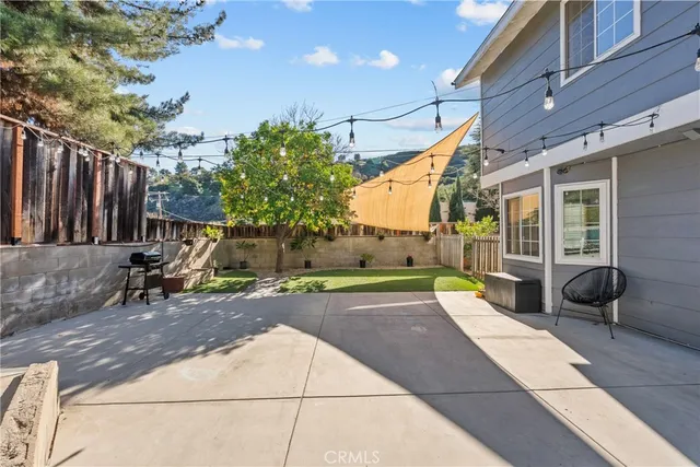 a view of a brick house with a lawn chairs next to a yard