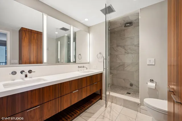 a bathroom with a double vanity sink toilet and shower