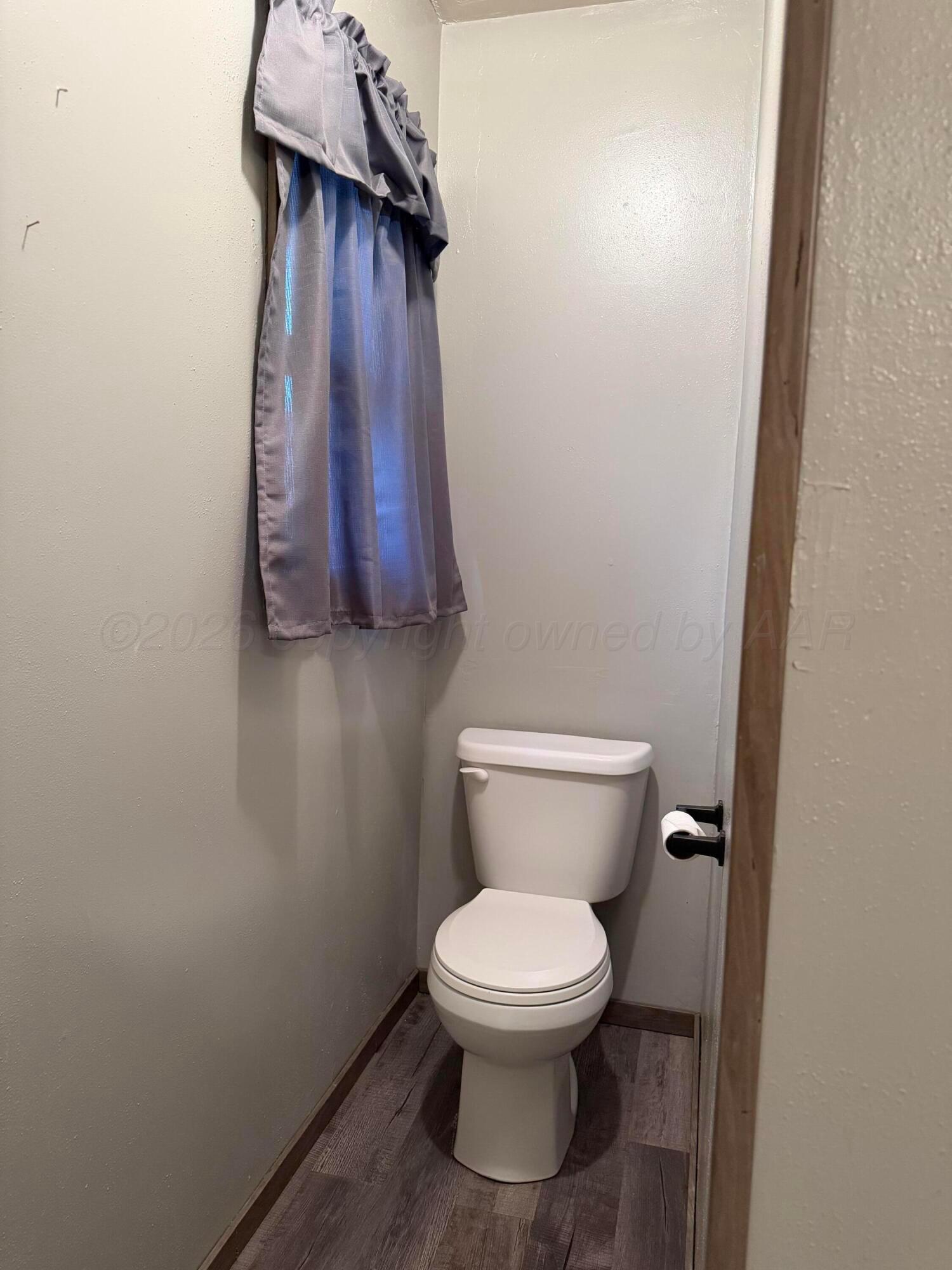 1313 Davis Street Borger, TX 79007 - Photo 13 of 15 a white toilet sitting next to a shower