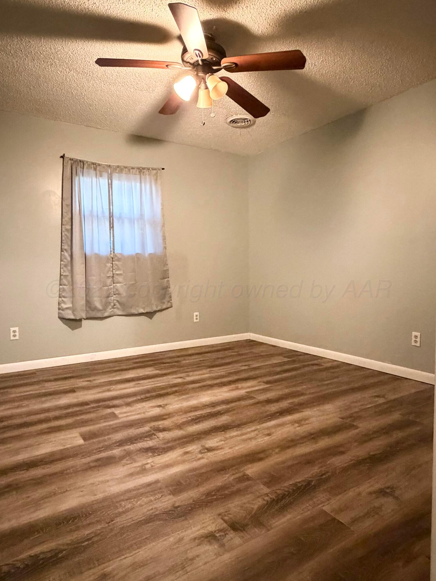 1313 Davis Street Borger, TX 79007 - Photo 14 of 15 a view of empty room with wooden floor and fan