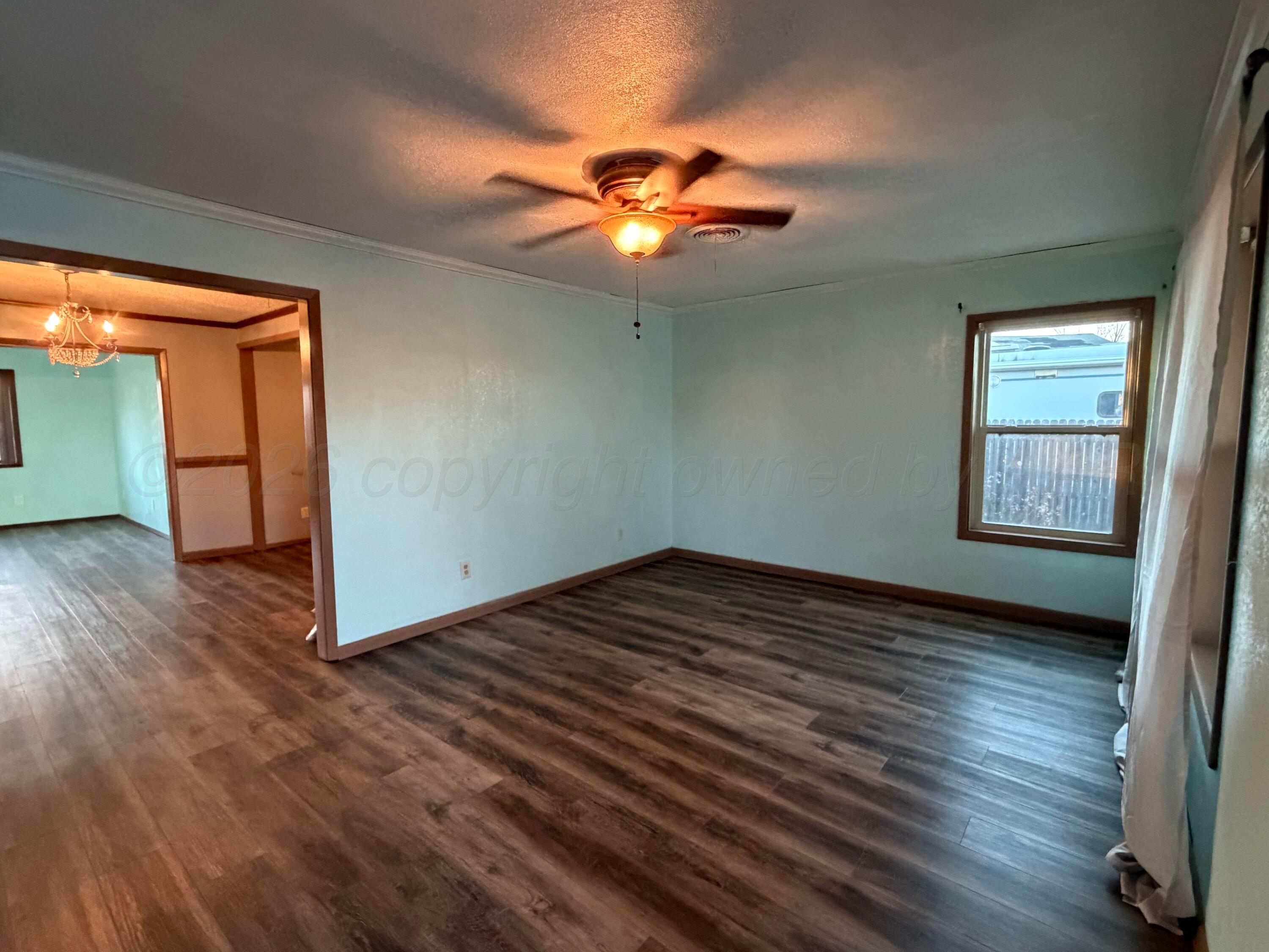 1313 Davis Street Borger, TX 79007 - Photo 3 of 15 a view of an empty room with window and wooden floor