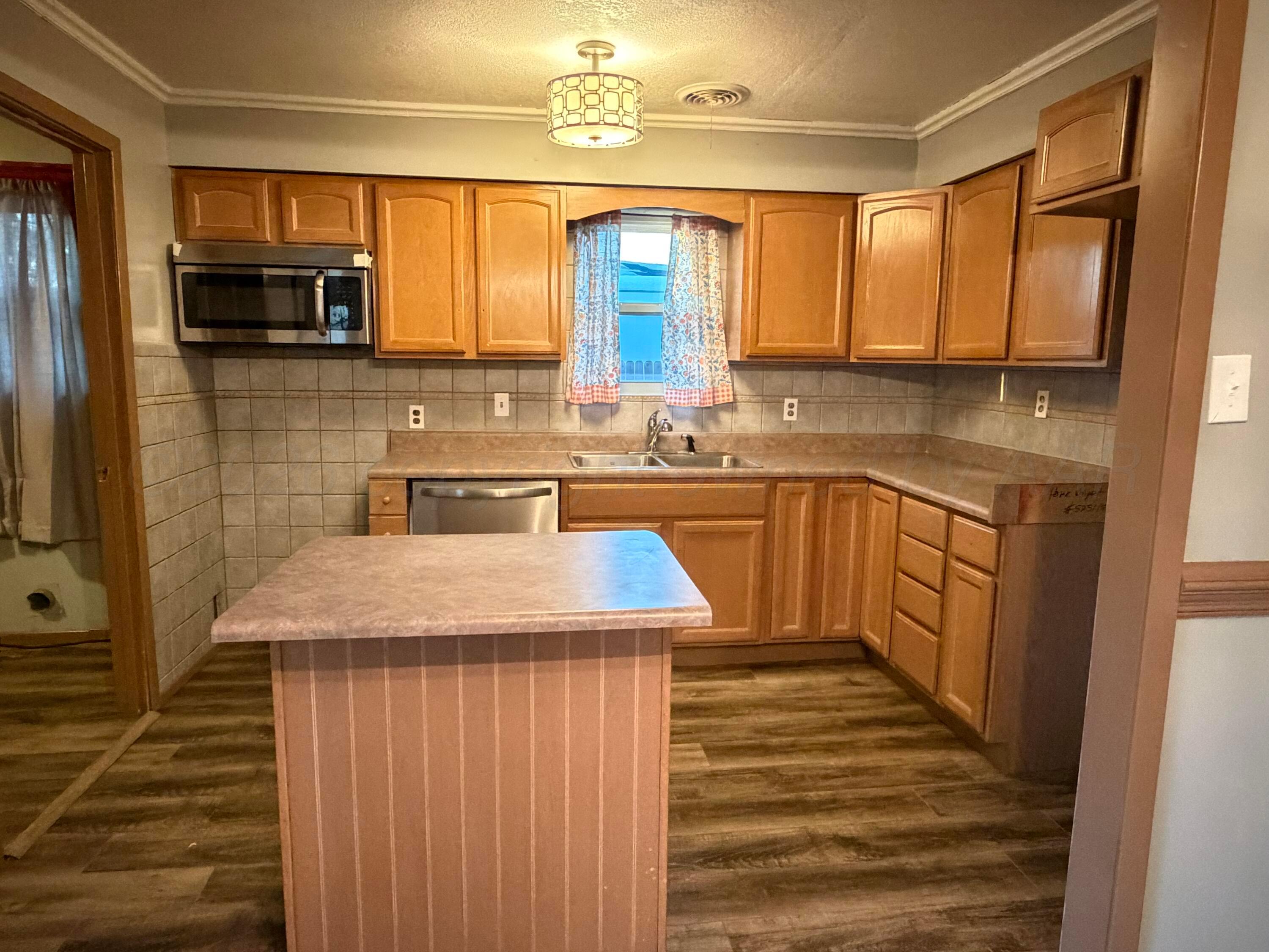 1313 Davis Street Borger, TX 79007 - Photo 6 of 15 a kitchen with stainless steel appliances granite countertop a sink stove and refrigerator