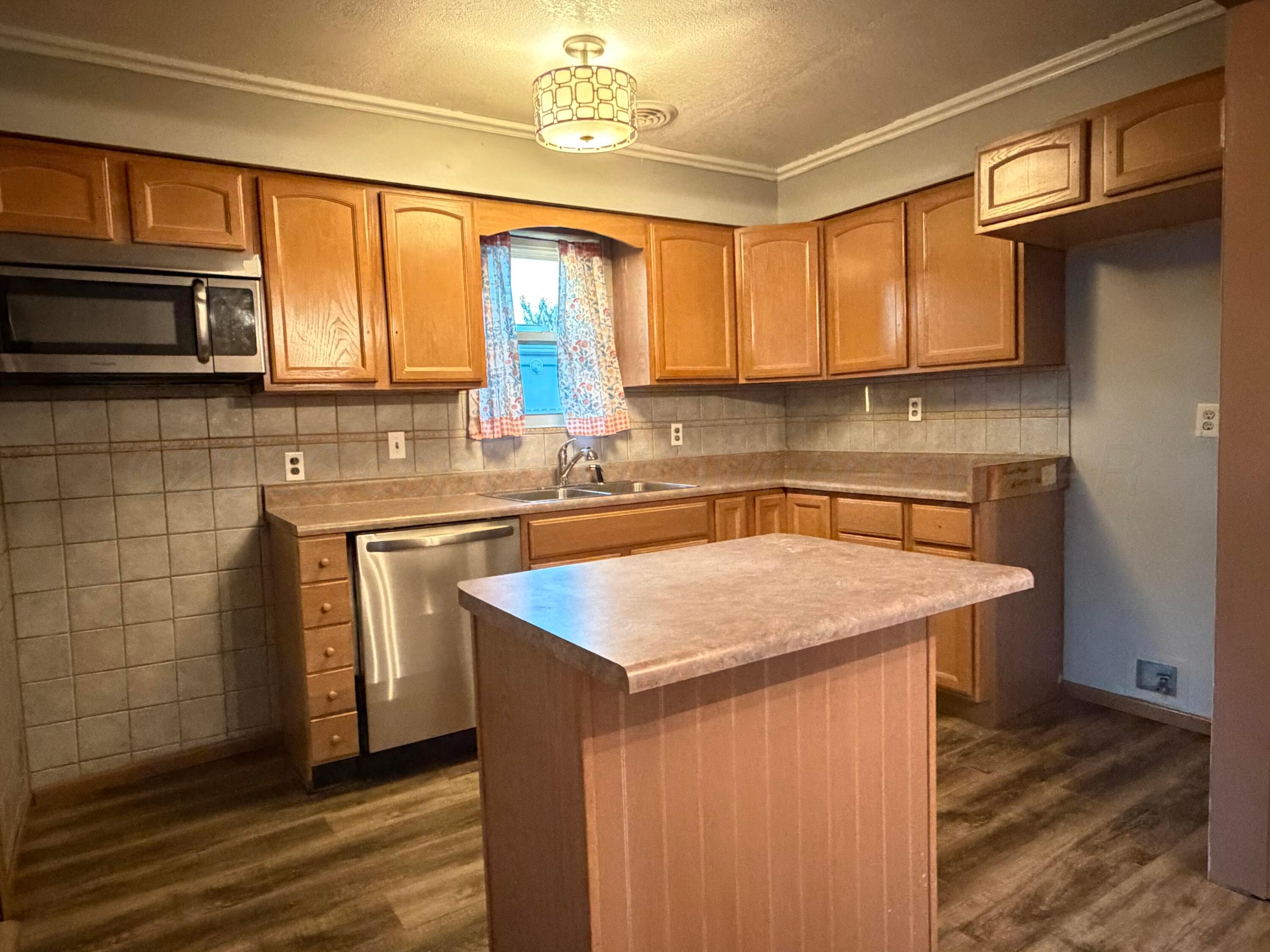 1313 Davis Street Borger, TX 79007 - Photo 7 of 15 a kitchen with stainless steel appliances granite countertop a sink stove and cabinets