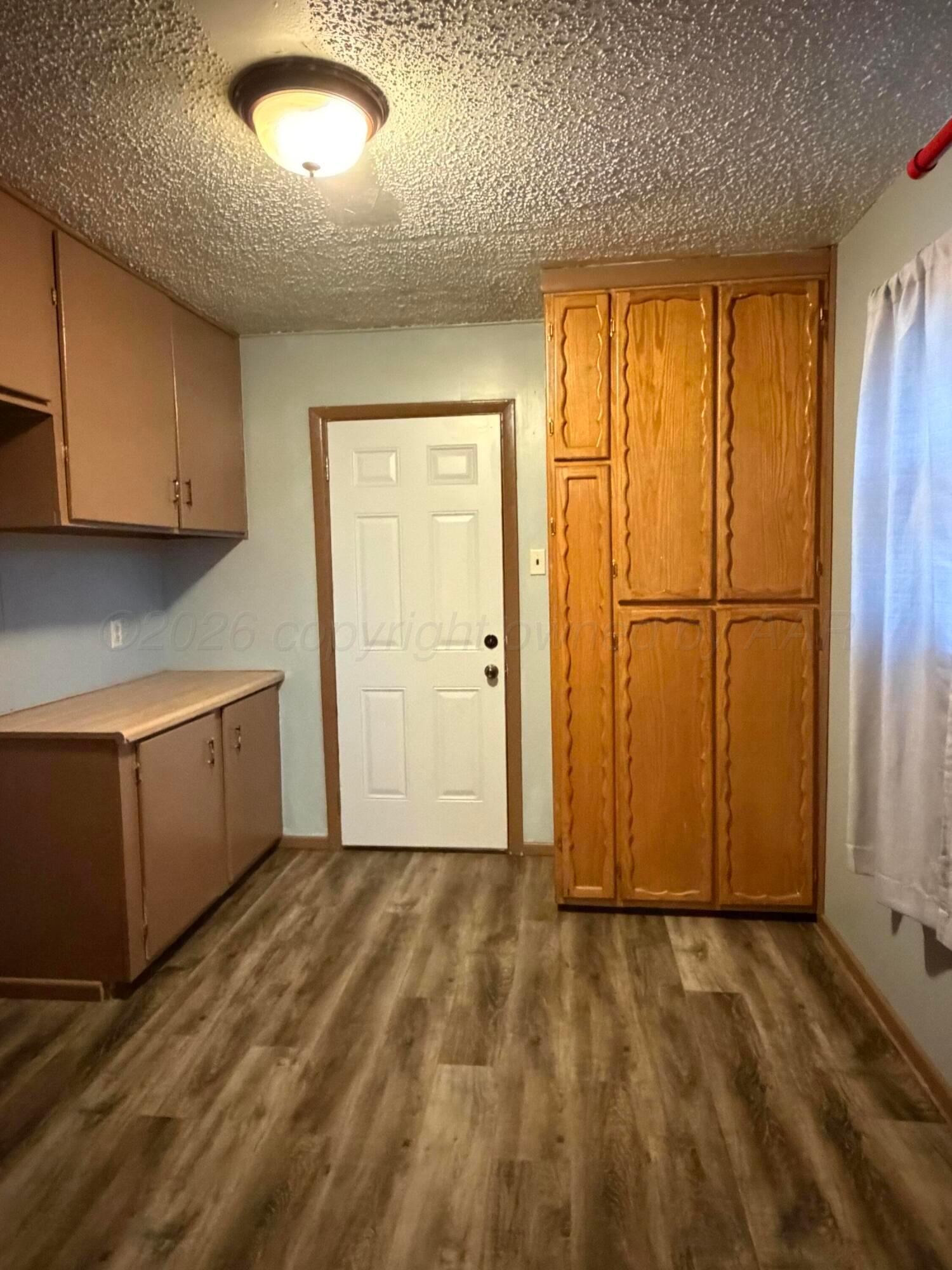 1313 Davis Street Borger, TX 79007 - Photo 8 of 15 a view of a room with wooden floor and cabinet