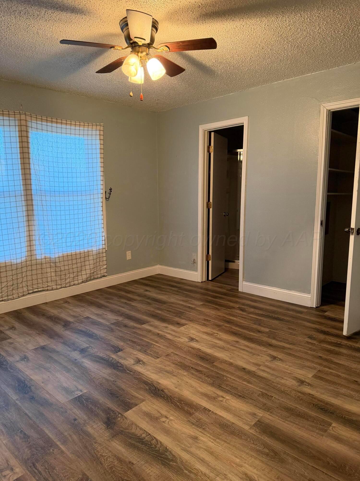1313 Davis Street Borger, TX 79007 - Photo 10 of 15 a view of an empty room with window and wooden floor