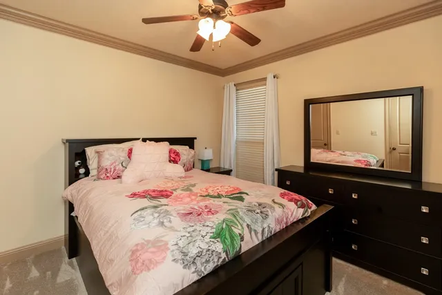 a bedroom with a bed and a flat tv screen on dresser