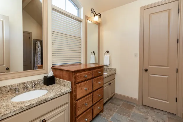 a bathroom with a granite countertop sink and a mirror