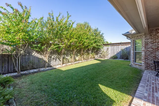 a view of a chair and table in backyard of the house