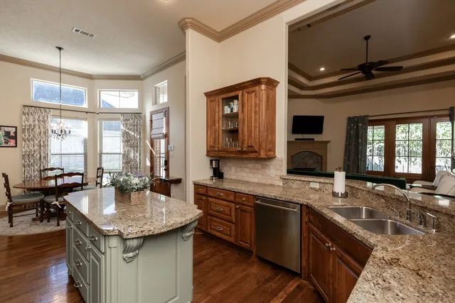 a kitchen with granite countertop a sink and a stove top oven with wooden floor