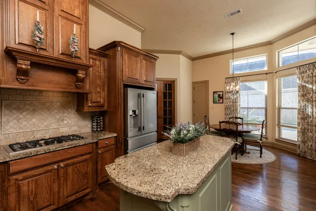 a kitchen with stainless steel appliances granite countertop a stove and a refrigerator