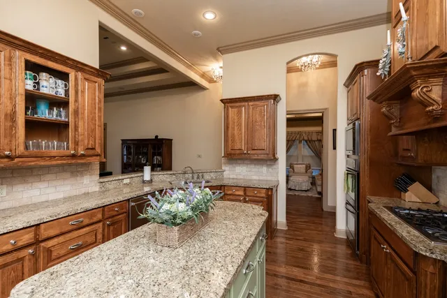 a kitchen with stainless steel appliances granite countertop a stove and a wooden floors