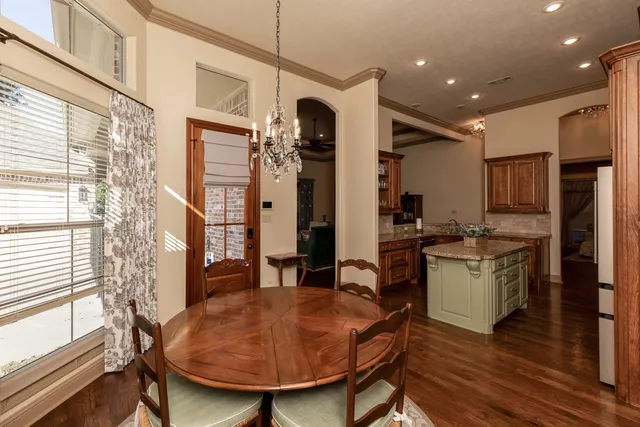 a kitchen with a table chairs refrigerator and cabinets