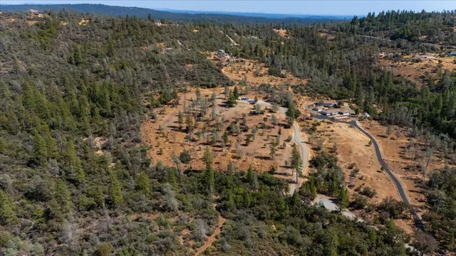 an aerial view of house with yard and mountain view in back