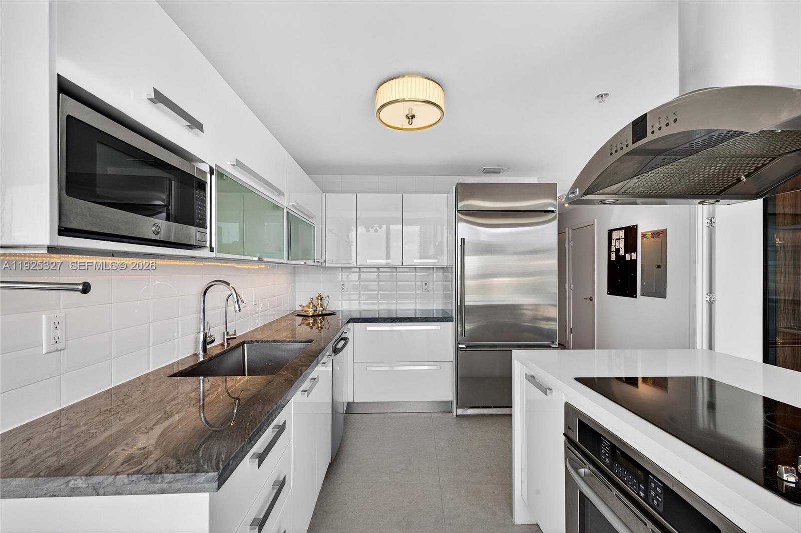 601 Northeast 36th Street, Unit 1101 Miami, FL 33137 - Photo 21 of 69 a kitchen with stainless steel appliances granite countertop a sink and a microwave