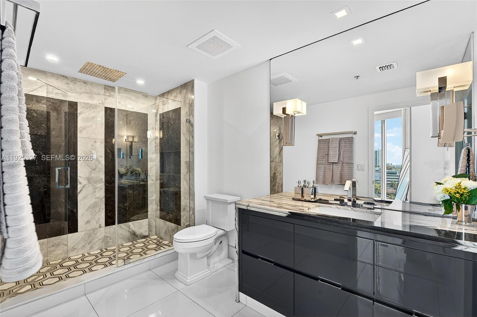 601 Northeast 36th Street, Unit 1101 Miami, FL 33137 - Photo 36 of 69 a bathroom with a double vanity sink toilet and shower