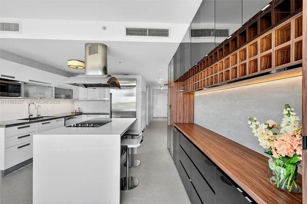 a living room with furniture a flat screen tv and kitchen view