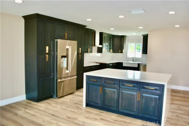 a kitchen with stainless steel appliances granite countertop a refrigerator and a sink