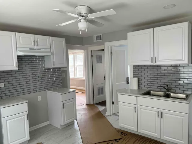 a kitchen with a sink a stove a refrigerator and cabinets
