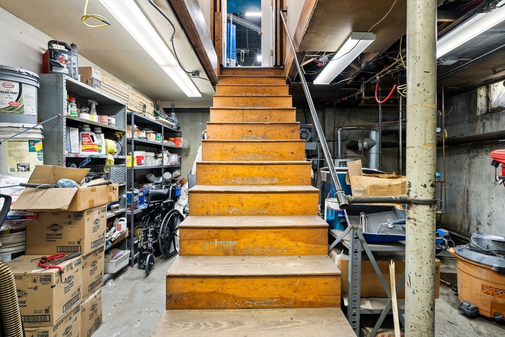 52-56 Dudley Street Arlington, MA 02476 - Photo 23 of 38 a view of staircase with lots of frames on wall and a fireplace