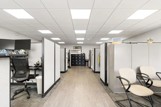 a view of a hallway with furniture and a refrigerator