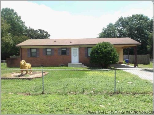 1402 Mack Street Spring Lake, NC 28390 - Photo 1 of 2 a backyard of a house with table and chairs under an umbrella