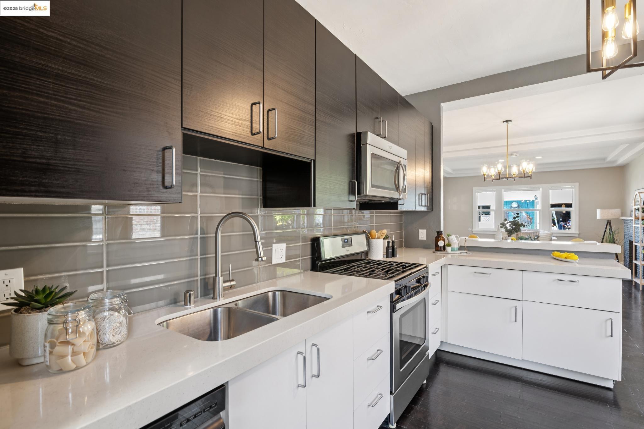 1092 Dwight Way Berkeley, CA 94710 - Photo 17 of 36 Kitchen featuring pendant lighting, appliances with stainless steel finishes, decorative backsplash, and dark wood finished floors