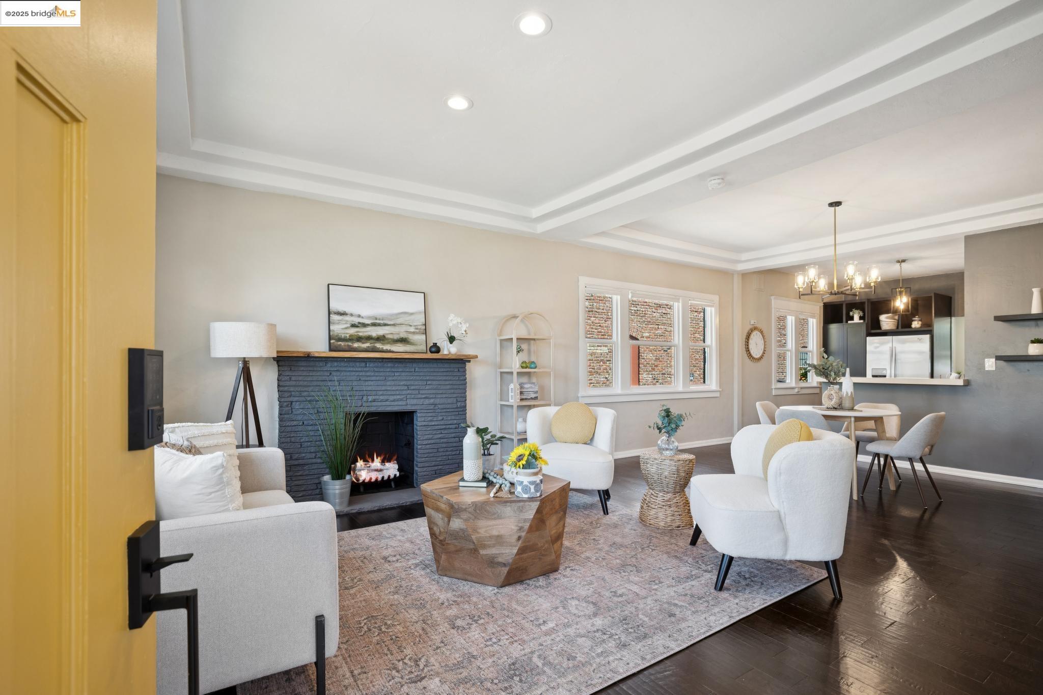 1092 Dwight Way Berkeley, CA 94710 - Photo 6 of 36 Living room with dark wood-type flooring, a brick fireplace, a tray ceiling, a chandelier, and recessed lighting