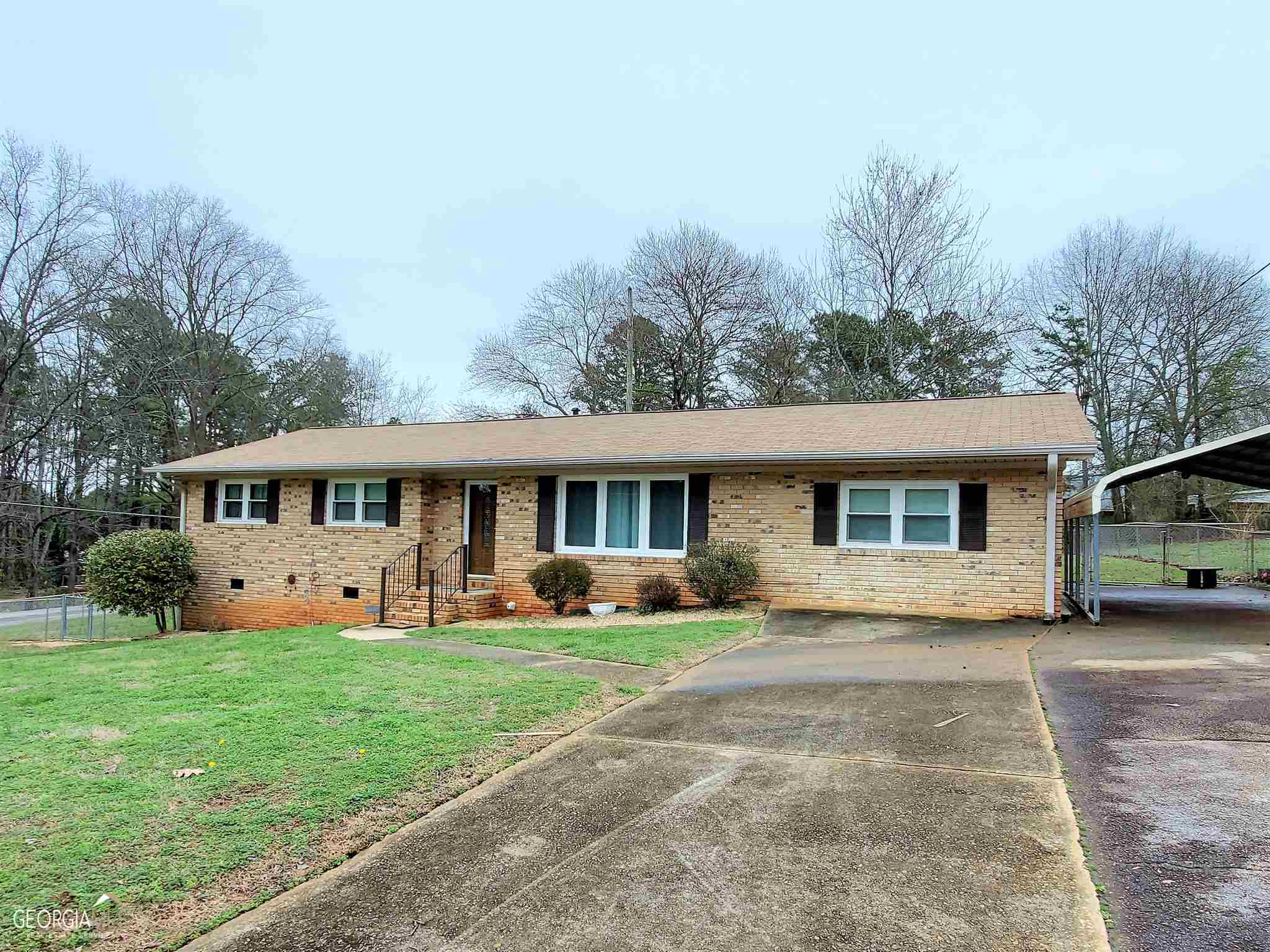a front view of a house with a garden and trees