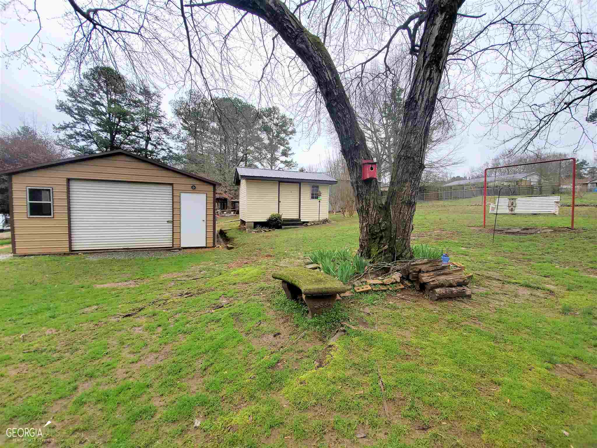 48 Leigh Street Commerce, GA 30529 - Photo 2 of 22 a backyard of a house with plants and large tree