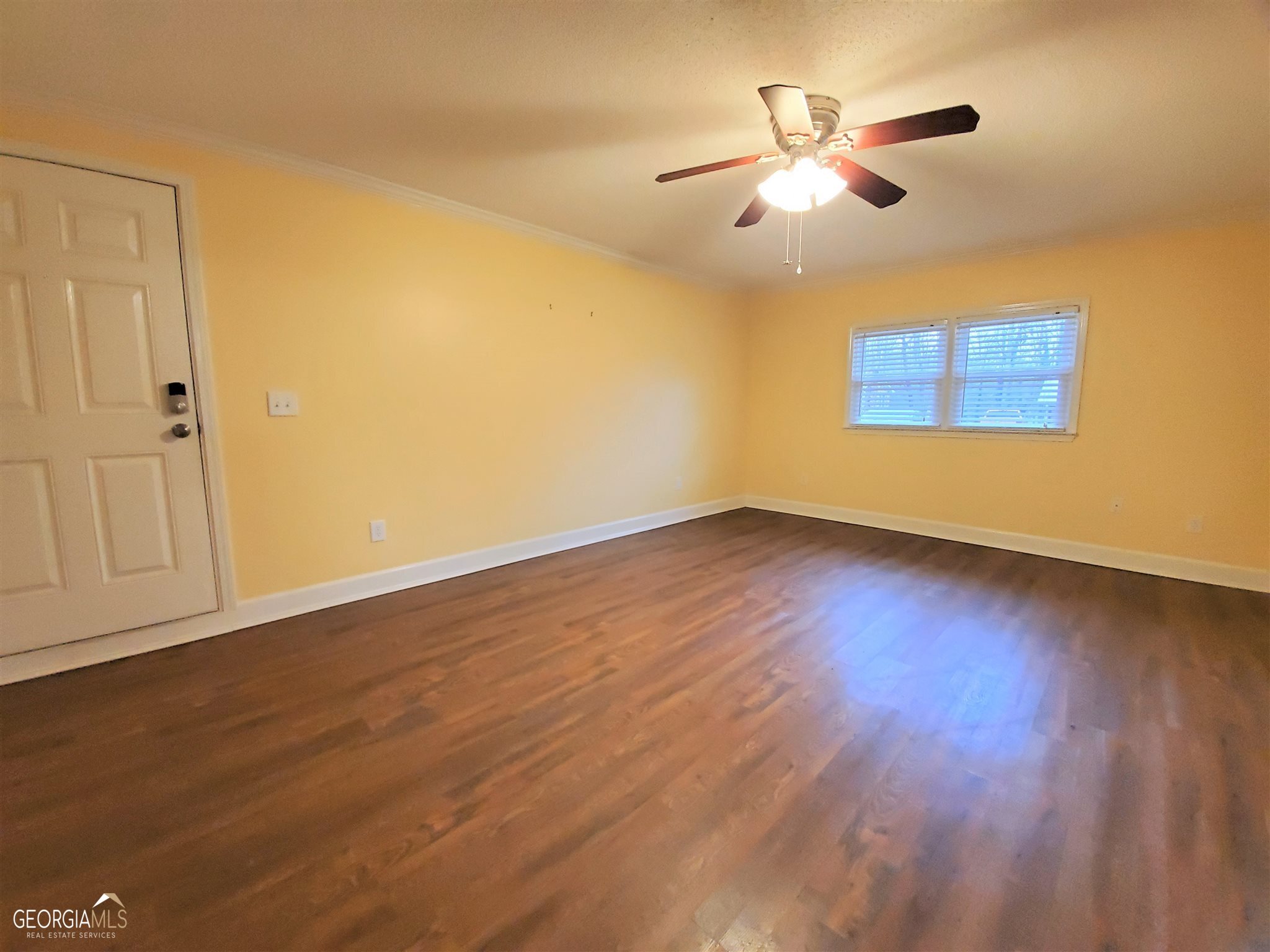 48 Leigh Street Commerce, GA 30529 - Photo 8 of 22 a view of an empty room with wooden floor and a ceiling fan
