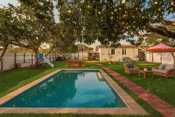 a view of a house with swimming pool and sitting area