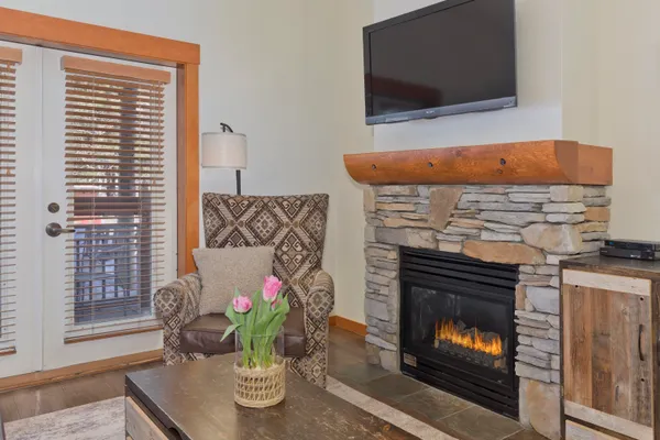 a living room with a fireplace wooden floor and a flat screen tv