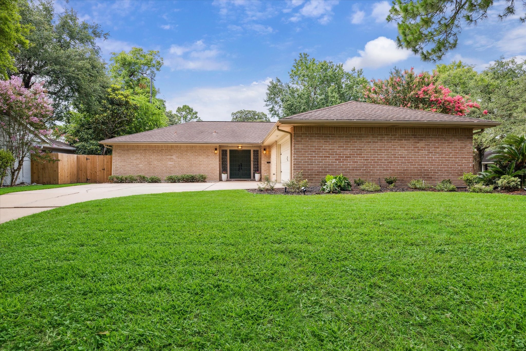 10002 Wickersham Lane Houston, TX 77042 - Photo 2 of 28 a front view of a house with a yard and a garage
