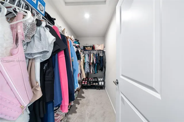a view of walk in closet with clothes