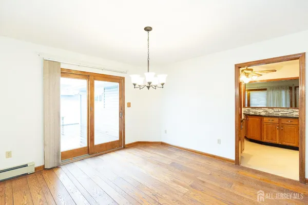 a view of a room with wooden floor and a ceiling fan