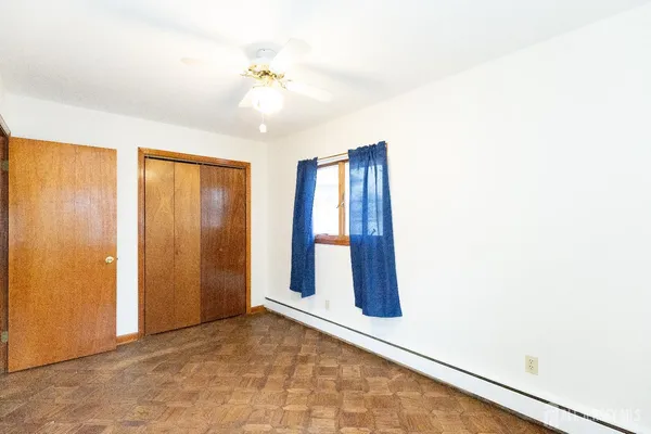 an empty room with windows and closet