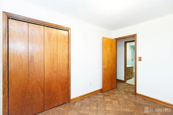 a view of an empty room with closet and a window