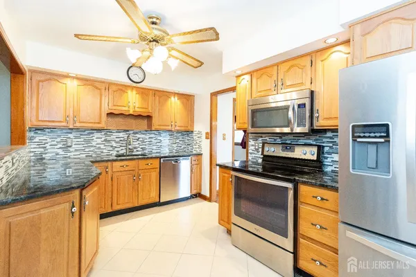 a kitchen with stainless steel appliances granite countertop a stove and a microwave
